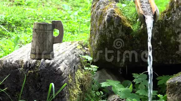 传统的乡村木杯水靠近纯净的山泉视频的预览图