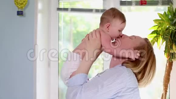 生命中最美好的时刻一位慈爱快乐的年轻母亲拥抱着一个哺乳的儿子拥抱在一条蓝色的毯子上上面有花拥抱在白色的毯子上视频的预览图