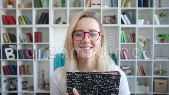 戴着眼镜手里拿着课本的女学生画像微笑着视频的预览图