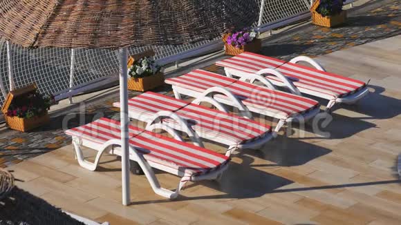 酒店和海滩附近的空床早上在海滩上海滩上有阳光和太阳伞视频的预览图