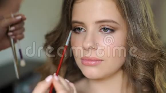化妆师训练学生进入决赛这个女孩在客户的脸上涂了一层刷子这就是视频的预览图