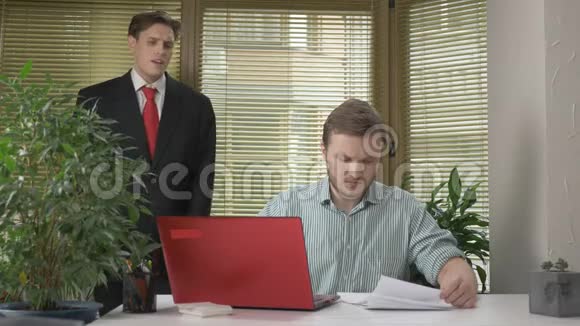 一个年轻的下属员工给老板带来了一份报告一份文件在老板看不到的情况下做鬼脸视频的预览图