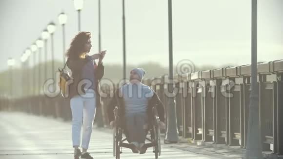 坐轮椅的残疾人在码头为年轻女子拍照视频的预览图