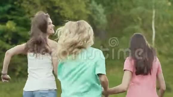 快乐的女孩有乐趣的朋友在大自然中奔跑户外视频的预览图