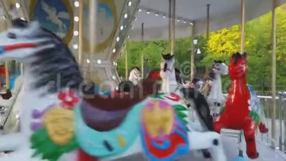 儿童户外五颜六色的复古梅里GoRound飞行马旋转木马在娱乐霍利迪公园在城市视频的预览图