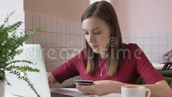 美丽的女性网上银行使用笔记本电脑在线购物与信用卡家庭生活方式60fps视频的预览图