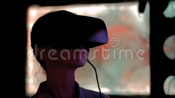 在黑暗互动展览中使用虚拟现实耳机的年轻女性视频的预览图