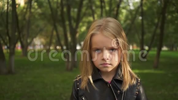 穿着皮夹克的小女孩在公园里视频的预览图