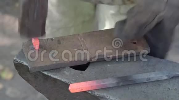 铁匠在铁砧上用烫红的铁条做钉头视频的预览图