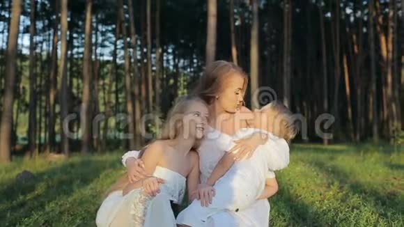 三口之家在森林里玩得开心穿着白色衣服和草帽的母亲和孩子们很高兴视频的预览图