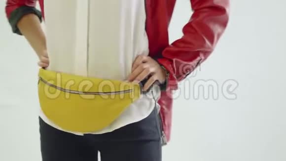 模特穿着红色外套和黑色裤子的姿势与黄色范尼包在臀部在照片拍摄现代趋势视频的预览图