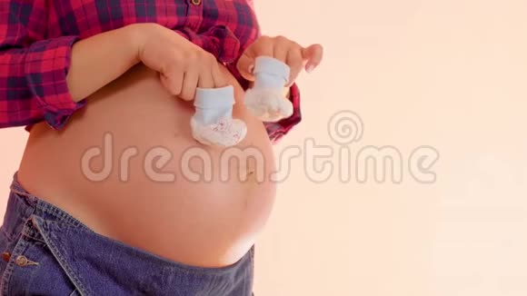 一个怀孕的女人的咪咪走在她赤裸的大肚子上带着可爱的小婴儿想让妈妈玩视频的预览图