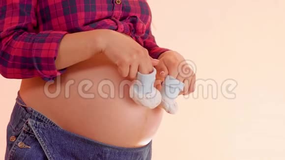 一个怀孕的女人的咪咪走在她赤裸的大肚子上带着可爱的小婴儿想让妈妈玩视频的预览图