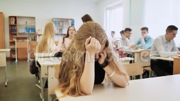 这个女孩是一个在课堂上哭泣的女学生她的同学安慰她视频的预览图