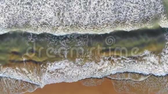 从空中俯瞰西班牙海滩海浪来到海岸在海岸外形成泡沫和气泡他的表情视频的预览图