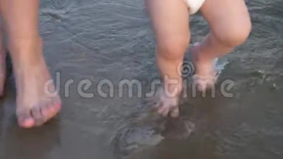 宝宝的腿上水宝宝和妈妈在沙滩上散步特写镜头慢动作视频的预览图