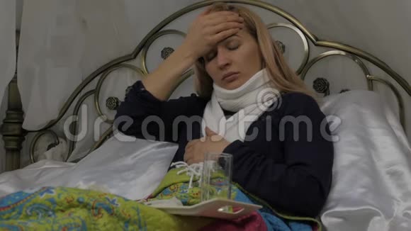生病的女人咳嗽喝了一片药女孩躺在床上脖子上戴着一条温暖的围巾慢动作视频的预览图