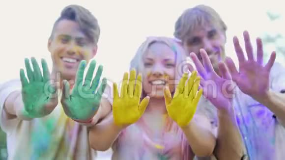 快乐的年轻人挥舞着五颜六色的手掌对着镜头慈善活动推广视频的预览图