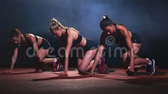 3名身穿黑色运动服的运动员晚上在跑步机上跑步将在短跑比赛中开始视频的预览图