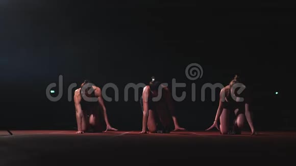 三个穿黑色衣服的女孩在起点垫上在灯笼的灯光下开始比赛视频的预览图