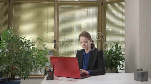一个穿西装的年轻人在办公室里和一个女孩调情给她一个绿色的Abloko一个女孩在电脑上工作一个红色的视频的预览图