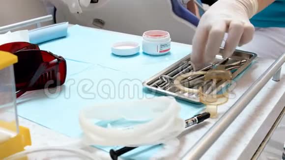 特写4k牙科医生手拿防护手术手套从桌子上拿器械的视频视频的预览图