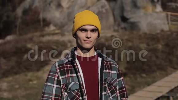 年轻的徒步旅行者站在山上微笑着走进镜头的肖像美丽的岩石背景户外活动视频的预览图
