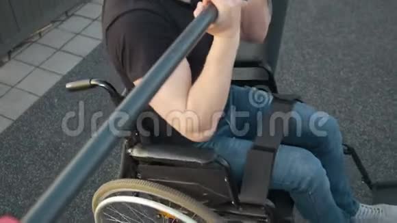 坐轮椅的肌肉残疾男子在户外的横杆上拉视频的预览图