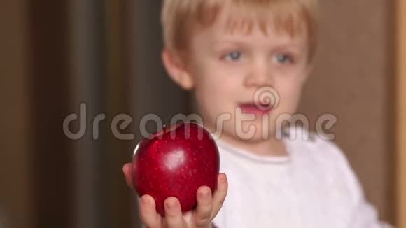 一个手里拿着一个红苹果的孩子的肖像视频的预览图