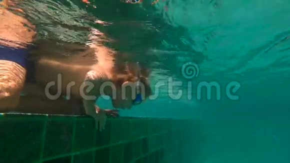 一个小男孩把头伸进水池里在水下拍摄的超HD慢动作视频的预览图