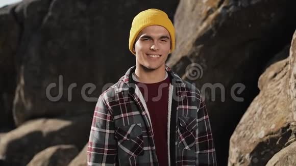 年轻的徒步旅行者站在山上微笑着走进镜头的肖像美丽的岩石背景户外活动视频的预览图