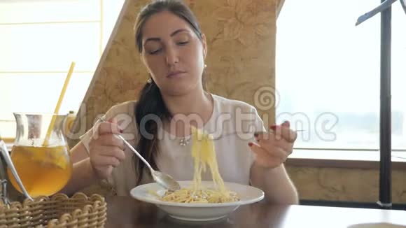 在咖啡馆里吃意大利面的年轻美女视频的预览图