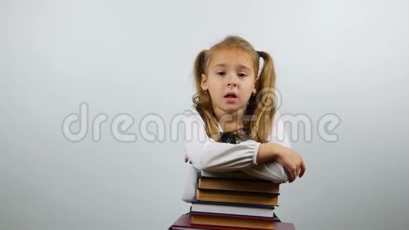 精疲力竭的女学生靠在书上年轻女孩疲惫的样子几乎不抬起头看着镜头视频的预览图