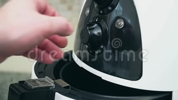 用手在厨房的工作表面前面有一个深油炸锅供家庭使用视频的预览图