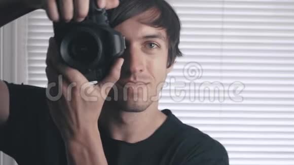 英俊的摄影师用他的相机拍照片男人在贾鲁西背景下拍摄单反相机视频的预览图