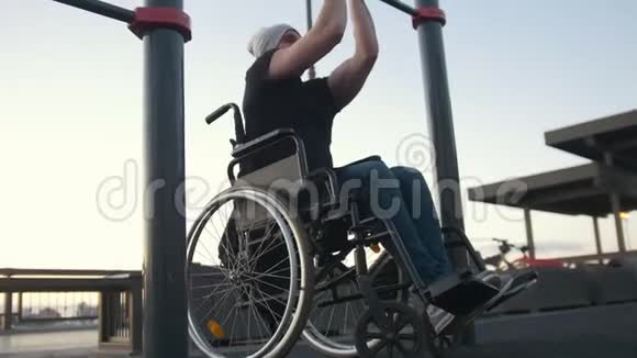 坐轮椅的青年残疾人在户外的横梁上视频的预览图
