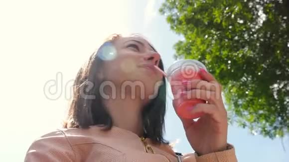 年轻迷人的高加索女人喝奶昔的城市肖像视频的预览图