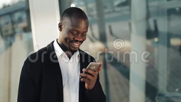 快乐的非裔美国商人欢呼庆祝看手机和持有大量的钱在他的视频的预览图
