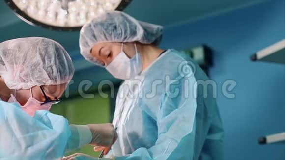 专业外科医生和助手在手术过程中讨论手术他们在现代化的医院手术室工作视频的预览图