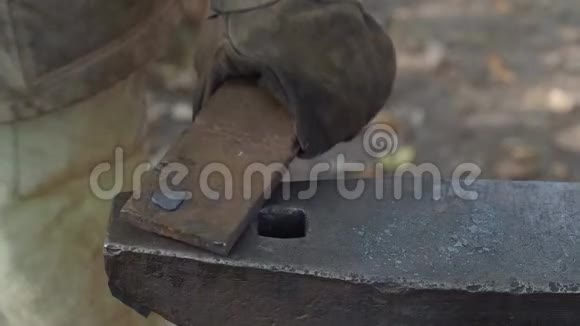 村铁匠在铁砧上锻铁工件的慢速运动视频的预览图