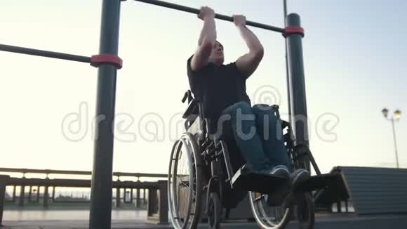 坐轮椅的青年残疾人在户外的横梁上视频的预览图
