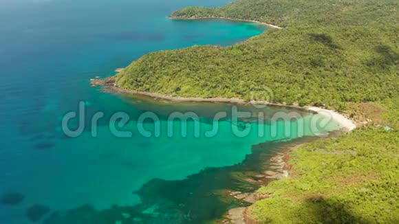 海湾有绿松石水和白色的小海滩美丽的泻湖和火山岛覆盖着茂密的森林视频的预览图