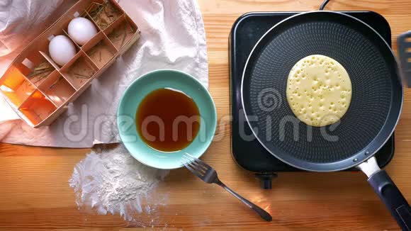 上桌美味的煎饼是用鸡蛋和蜂蜜从锅两边煎出来的另外还有面粉制品烹饪视频的预览图