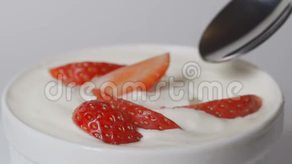用勺子吃草莓的慢动作视频的预览图