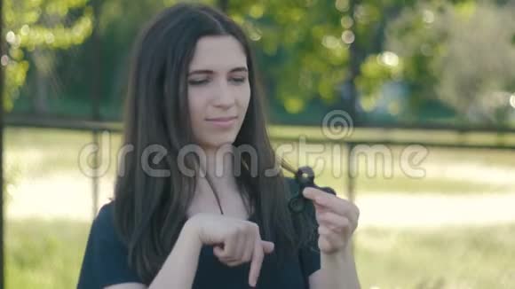 年轻女子在户外用手旋转一个旋转器女纺纱机视频的预览图