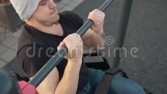 坐轮椅的肌肉残疾男子在户外的横杆上拉视频的预览图