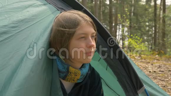 女孩从森林里的帐篷里往外看视频的预览图