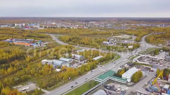 鸟瞰美丽的秋树和城市的工业区与建筑物剪辑很多人开着车视频的预览图