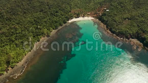 海湾有绿松石水和白色的小海滩美丽的泻湖和火山岛覆盖着茂密的森林视频的预览图