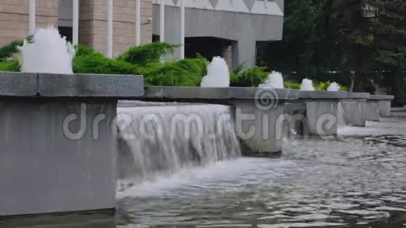 夏季一天从混凝土城市喷泉特写处浇水视频的预览图